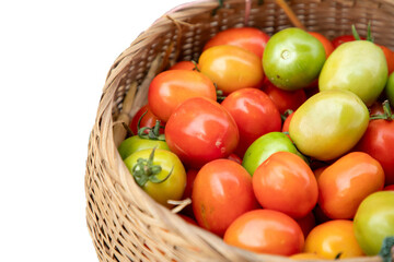 Colorful tomatoes in a basket isolated on white background, selective focus