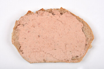 A slice of bread is generously spread with a smooth, light brown pate