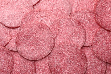 Slices of tasty smoked sausage as background, top view