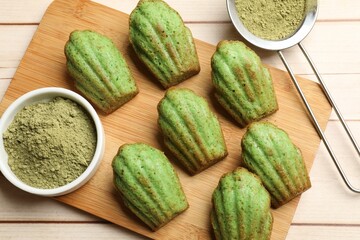 Tasty matcha madeleine cakes on light wooden table, top view