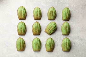 Tasty matcha madeleine cakes on light table, flat lay