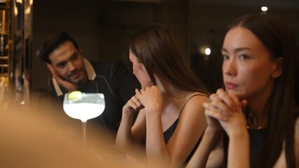 Couple talking at sitting bar with Margarita cocktail savoring sour tasty drink in happiness moment meeting while woman waiting friends at front view at luxurious counter vibrant nightclub. Vinosity.