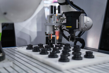 Close up industrial automation gripping robot working with metalwork on CNC machine on smart manufacturing and right copy space