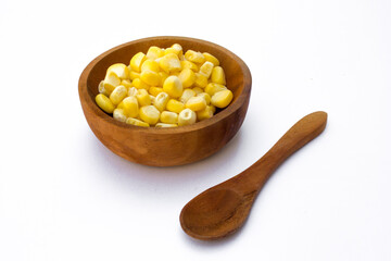 A wooden bowl with corn kernels, isolated on white background.