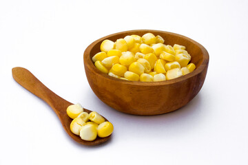 A wooden bowl with corn kernels, isolated on white background.