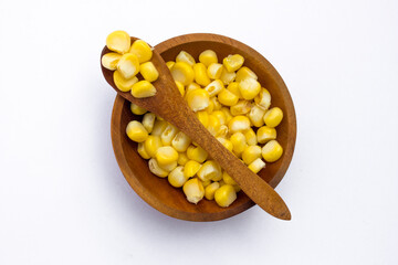 A wooden bowl with corn kernels, isolated on white background.