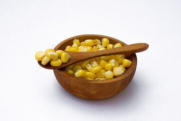A wooden bowl with corn kernels, isolated on white background.