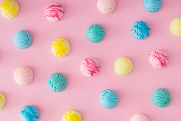 Colorful pattern composition made of various ice cream scoops on pastel pink background. Minimal summer concept. Trendy sweet dessert idea background. Ice cream aesthetic backdrop. Flat lay style.