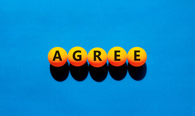Agree symbol. Concept word Agree on beautiful yellow tennis ping pong balls. Beautiful wooden table...