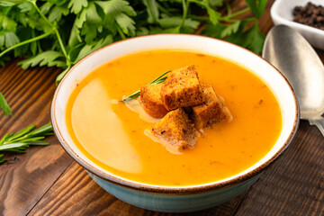 Delicious lentil, ezogelin or pumpkin soup on wooden background