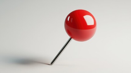 Glossy, red pushpin on a light background.