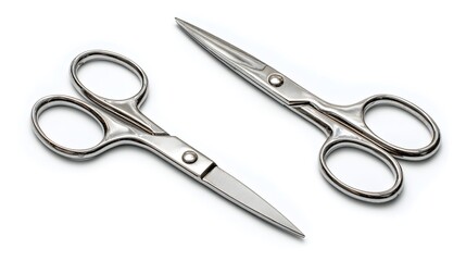 Obraz premium A pair of shiny, silver scissors with sharp blades laid on a bright white surface.