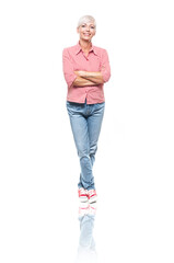 Full length portrait of positive adult woman with crossed arms, isolated on white background. Cheerful middle aged woman standing and looking to camera.