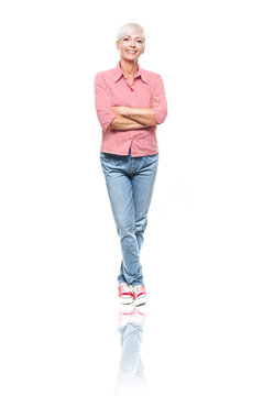 Full length portrait of positive adult woman with crossed arms, isolated on white background. Cheerful middle aged woman standing and looking to camera.
