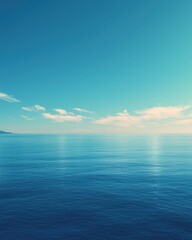 Obraz premium Serene ocean landscape under a clear, blue sky. Calm waters reflect the sunlight, creating a peaceful scene