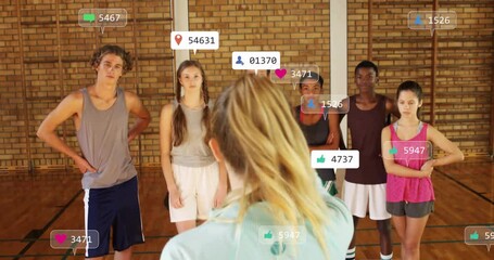 Coach pointing student athletes in sports gym while social media reaction icons floating above - Powered by Adobe