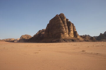 Rocky hillside against a clear blue sky. The sky is very bright, and the sun is shining. The desert is very hot for life, ecology, the heat is very high, there is no vegetation