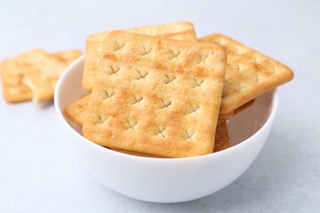 Tasty salty crackers on white table, closeup