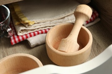 Wooden mortar and pestle in drawer indoors, closeup