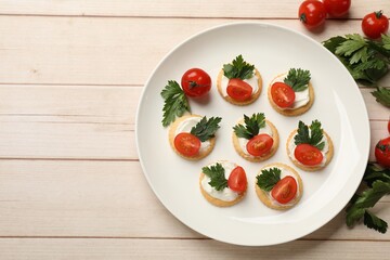 Tasty crackers with cream cheese, tomatoes and parsley on white wooden table, flat lay. Space for text