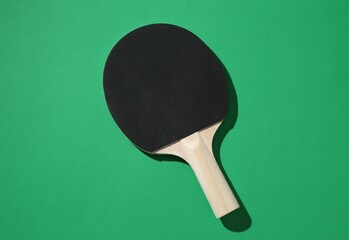 One ping pong racket on green background, top view