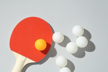 Ping pong racket and balls on light background, flat lay