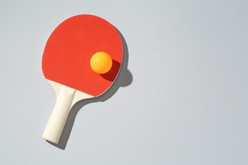 Ping pong racket and ball on light background, top view. Space for text
