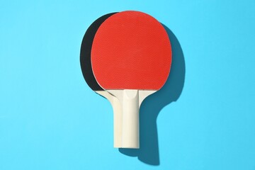 Ping pong rackets on blue background, top view