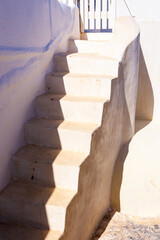 A stair with shadow during the day time is shown. Santorini island, Greece. 
