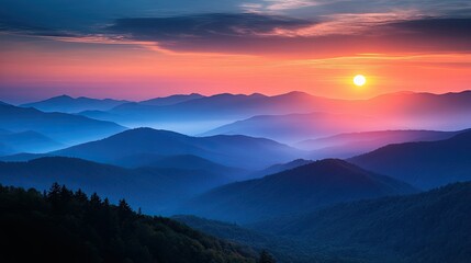 Obraz premium Sunrise over hazy mountain ranges with pink and orange sky and trees in the foreground view