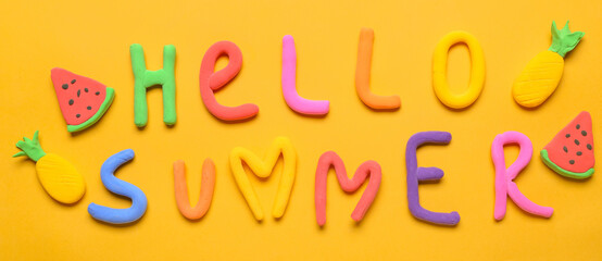 Fruits and text HELLO SUMMER made of plasticine on orange background