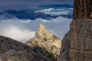 Above the clouds Dolomites rocky peaks. Towering cliffs above the clouds on the blue sky. Dolomites Alps. Beautiful landscape of the rocky cliffs in Dolomiti Alps