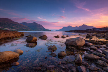 Sunset Over Rocky Shoreline and Mountain Landscape
