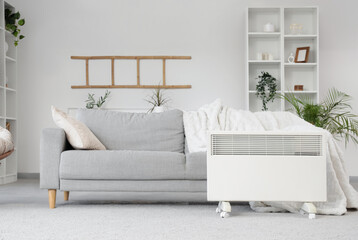 Electric heater on floor near sofa in living room