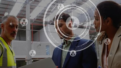 Team reviewing laptop data in manufacturing plant showing animated network graphics and user icons - Powered by Adobe