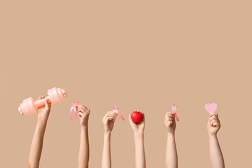 Female hands with dumbbell, hearts and pink ribbons on color background. Breast cancer awareness concept