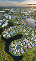 Upscale suburban homes at sunset with large backyards and green grassy lawns. Private residential...