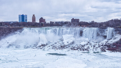 The American falls at Niagara falls, USA, from the American Side during a sunny day in Niagara Falls, Ontario, Canada. This was on a sunny spring afternoon with blue skies.