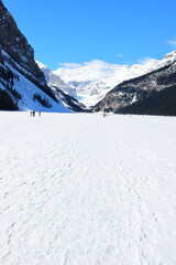 Lake Louise, Alberta, Canada - Apr 13, 2025: Tourists walking on the frozen Lake Louise. Beautiful...