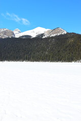 Lake Louise, Alberta, Canada - Apr 13, 2025: Tourists walking on the frozen Lake Louise. Beautiful...