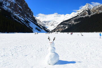 Lake Louise, Alberta, Canada - Apr 13, 2025: Tourists walking on the frozen Lake Louise. Beautiful Lake Louise in spring. The lake is frozen with unreal, scenic nature views in popular tourism area.