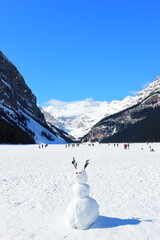 Lake Louise, Alberta, Canada - Apr 13, 2025: Tourists walking on the frozen Lake Louise. Beautiful Lake Louise in spring. The lake is frozen with unreal, scenic nature views in popular tourism area.