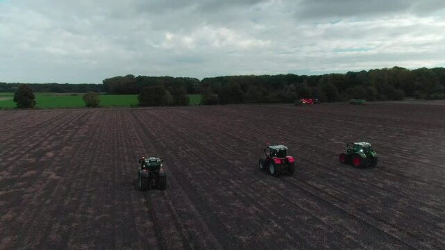 Drone Footage of Tractors Driving and Standing on Farmland &ndash; Aerial View of Agricultural Machinery in Action
