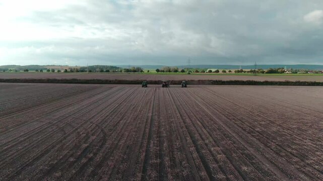 Drone Footage of Tractors Driving and Standing on Farmland &ndash; Aerial View of Agricultural Machinery in Action