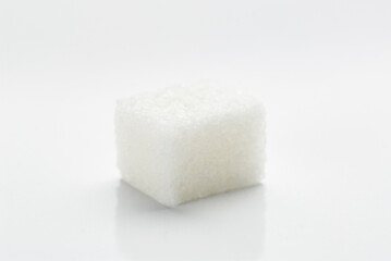Close-Up of a Single White Sugar Cube on White Background..