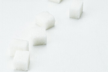 White Sugar Cubes Arranged on a Clean White Background Surface..