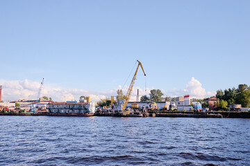 Industrial Harbor Dockyard Scene with Machinery and Shipping Containers by the Water..