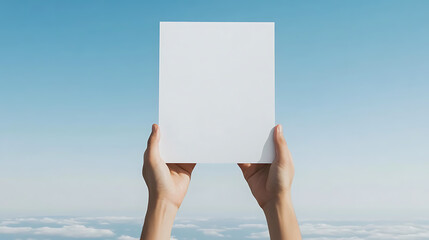 Holding a blank white card against a serene sky backdrop, symbolizing a fresh start, a blank slate, and endless possibilities for new ideas.