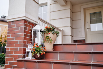 Elegant Front Porch Decor with Flowers and Lanterns on Brick Steps..