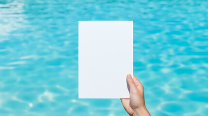 White paper held over shimmering turquoise water. A simple, clean aesthetic for announcements, invitations, or artistic display. Water creates a calming backdrop.